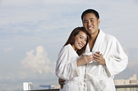 Young couple in robes hugging and smiling - Yukmin