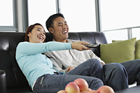 Young couple watching TV and laughing - Yukmin