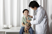 Doctor giving a little boy a check up - Yukmin