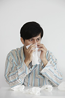 young man blowing his nose with tissue - Yukmin