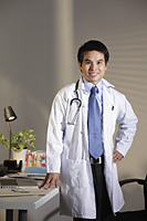 Doctor standing in office smiling - Yukmin