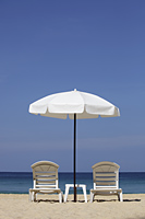 White umbrella and chairs on beach - Yukmin