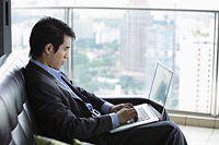 Profile of man using laptop in front of window - Yukmin