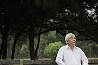 Older man with white hair sitting in park - Yukmin