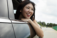 Young woman with head out the car window laughing - Yukmin