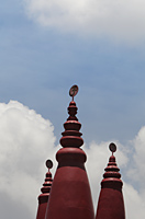 Red turrets of Hindu temple with "OM" in Sanskrit on top. - Alex Mares-Manton