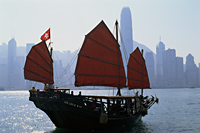China,Hong Kong,Victoria Harbour,Tourists on Junk and City Skyline in Background - Travelasia