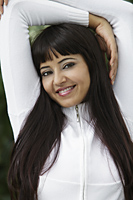 Head shot of woman with long hair and arms overhead smiling - Alex Mares-Manton