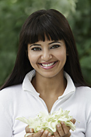 Head shot of smiling woman holding flowers - Alex Mares-Manton
