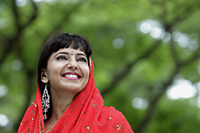 Head shot of Indian woman smiling with red sari over her head - Alex Mares-Manton