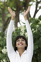Head shot of woman smiling with arms outstretched overhead - Alex Mares-Manton