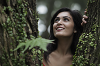 Head shot of young woman looking through a tree and smiling - Alex Mares-Manton