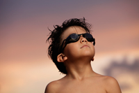 young boy looking up with goggles on at sunset - Yukmin