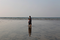 Father and son standing on the beach and looking at the horizon - Yukmin
