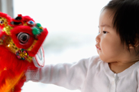 profile of baby looking at Chinese dragon toy - Yukmin