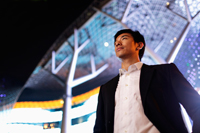 young man in suit standing in front of building at night - Yukmin