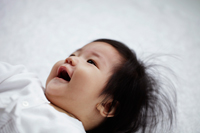 Chinese baby laying on back smiling - Yukmin