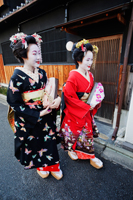 Geishas walking down the street in traditional Japanese clothing - Travelasia
