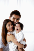 Mother and father holding crying baby - Yukmin