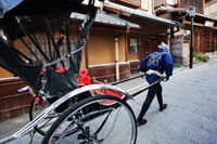 man pulling rickshaw in front of houses. Japan,Kyoto - Travelasia
