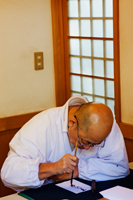 Ujigami Shrine, Priest doing Calligraphy with brush and ink. Kyoto, Japan - Travelasia