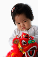 Baby holding red Chinese dragon toy - Yukmin