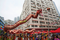 Traditional Chinese Dragon dance being performed on the street, Tai Kok Tsui Temple Fair. Hong Kong, China - Travelasia