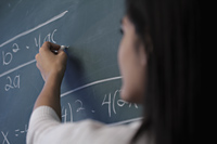 Close up of woman writing on chalk board, selective focus - Alex Mares-Manton