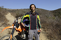 Man stands in front of off road motorcycle. - Yukmin