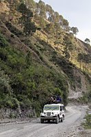 Men riding on the roof of a truck through the Himalayan Mountains, India - Alex Mares-Manton
