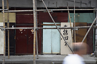 Old wall made of doors in Shanghai with bamboo scaffolding - Yukmin
