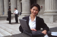 Female executive with laptop computer, smiling - Alex Microstock02