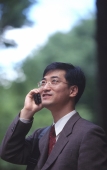 Male executive talking on cellular phone, trees behind - Alex Microstock02