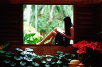 Woman sitting on window ledge, reading - John McDermott