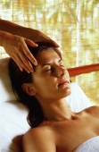 Caucasian female receiving a head massage, eyes closed - John McDermott