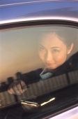 Female executive with palmtop, looking out of car window - Jade Lee