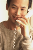 Man talking on telephone, smiling - Jade Lee