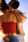 Couple embracing, woman with tattoo of Chinese characters on waist - Keith Brofsky