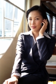 Female executive talking on cellular phone, portrait - Gareth Brown