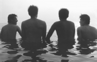 Teenagers wading in ocean, rear view, silhouette - Jade Lee