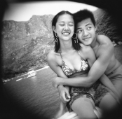 Teenage couple embracing with ocean view behind - Jade Lee