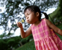 Girl blowing bubbles, tree in background - Alex Microstock02