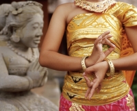 Indonesia, Bali, Balinese dancer close up, statue in background - Jack Hollingsworth