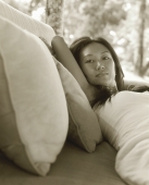 Woman lying on pillows, portrait - Jack Hollingsworth