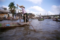 Vietnam, Mekong Delta, Phung Hiep, woman paddling boat in floating market. - Steve Raymer