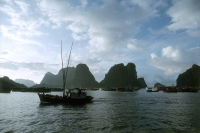 Vietnam, Halong Bay, fishing boat under cloudy sky. - Steve Raymer
