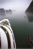 Vietnam, Halong Bay, cruise ship and small fishing boat. - Steve Raymer