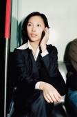 Female executive in subway train, talking on cellular phone - Gareth Brown