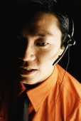 Male executive using telephone headset, portrait - Jade Lee