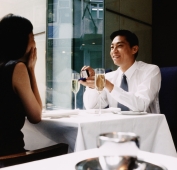 Man proposing to woman in restaurant with engagement ring - Jade Lee